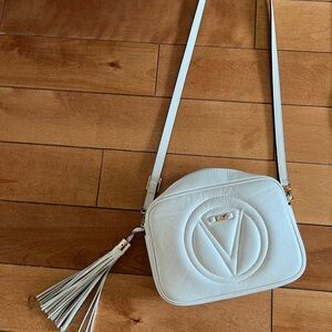Chic White Crossbody Bag with Embossed Design and Tassel.